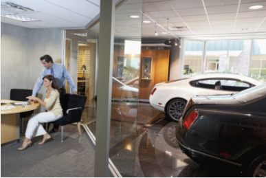 Salesman and woman in office at car dealer